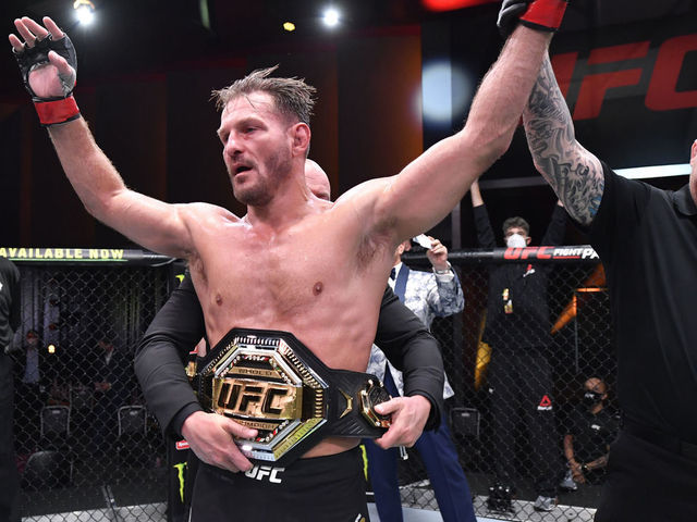 Stipe Miocic raising his arms with the UFC heavyweight championship belt around his waist